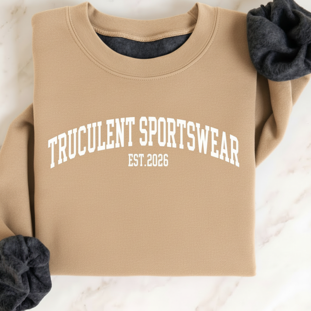 Sand crewneck sweatshirt laid flat on marble with arched white TRUCULENT SPORTSWEAR lettering and EST.2026 underneath